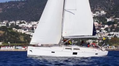 Bodrum, Hindi. 13 Ocak 2024: Yelkenliler Ege Denizi 'nin mavi sularında, ünlü tatil beldesi Bodrum' un kıyılarında rüzgarlı havada yelken açıyorlar..