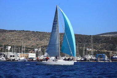 Bodrum, Hindi. 13 Ocak 2024: Yelkenliler Ege Denizi 'nin mavi sularında, ünlü tatil beldesi Bodrum' un kıyılarında rüzgarlı havada yelken açıyorlar..