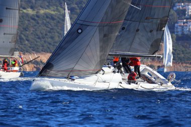 Bodrum, Hindi. 14 Ocak 2024: Yelkenliler Ege Denizi 'nin mavi sularında, ünlü tatil beldesi Bodrum' un kıyılarında rüzgarlı havada yelken açıyorlar..