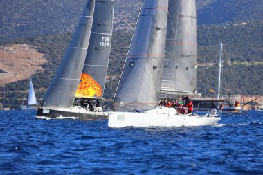 Bodrum, Hindi. 14 Ocak 2024: Yelkenliler Ege Denizi 'nin mavi sularında, ünlü tatil beldesi Bodrum' un kıyılarında rüzgarlı havada yelken açıyorlar..