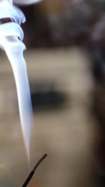 Tütsü çubuğu ve tütsü yanığından çıkan duman. Güzel duman. Fotokopi alanı ile bulanık arkaplan ve tasarım. Sosyal medya için dikey video.