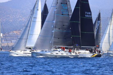 Bodrum, Hindi. 03 Şubat 2024: Ege Denizi 'nin mavi sularında, ünlü tatil beldesi Bodrum' un kıyılarında yelkenliler rüzgarlı havada yelken açıyor.