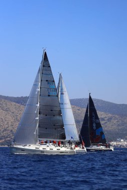 Bodrum, Hindi. 03 Şubat 2024: Ege Denizi 'nin mavi sularında, ünlü tatil beldesi Bodrum' un kıyılarında yelkenliler rüzgarlı havada yelken açıyor.