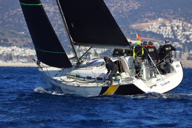 Bodrum, Hindi. 03 Şubat 2024: Ege Denizi 'nin mavi sularında, ünlü tatil beldesi Bodrum' un kıyılarında yelkenliler rüzgarlı havada yelken açıyor.