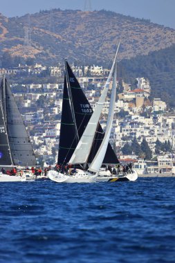 Bodrum, Hindi. 03 Şubat 2024: Ege Denizi 'nin mavi sularında, ünlü tatil beldesi Bodrum' un kıyılarında yelkenliler rüzgarlı havada yelken açıyor.
