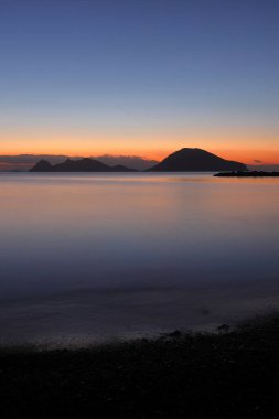 Sahilde gün batımı. Deniz kenti Turgutreis ve muhteşem gün batımları. Seçici Odaklanma. Uzun pozlu çekim. Huzur sahnesi.