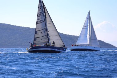 Bodrum, Hindi. 03 Şubat 2024: Ege Denizi 'nin mavi sularında, ünlü tatil beldesi Bodrum' un kıyılarında yelkenliler rüzgarlı havada yelken açıyor.