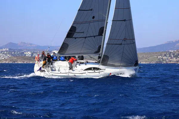 Bodrum, Hindi. 03 Şubat 2024: Ege Denizi 'nin mavi sularında, ünlü tatil beldesi Bodrum' un kıyılarında yelkenliler rüzgarlı havada yelken açıyor.