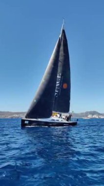 Bodrum, Hindi. 23 Şubat 2024: Yelkenliler Ege Denizi 'nin mavi sularında, ünlü tatil beldesi Bodrum' un kıyılarında rüzgarlı havada yelken açıyorlar. Sosyal medya için dikey video. 