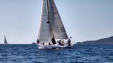 Bodrum, Hindi. 23 Şubat 2024: Yelkenliler Ege Denizi 'nin mavi sularında, ünlü tatil beldesi Bodrum' un kıyılarında rüzgarlı havada yelken açtılar..