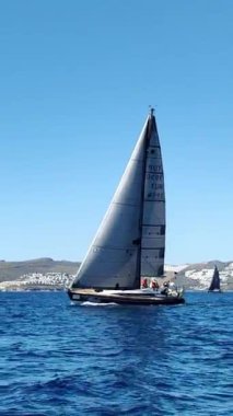 Bodrum, Hindi. 23 Şubat 2024: Yelkenliler Ege Denizi 'nin mavi sularında, ünlü tatil beldesi Bodrum' un kıyılarında rüzgarlı havada yelken açıyorlar. Sosyal medya için dikey video. 
