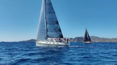 Bodrum, Hindi. 23 Şubat 2024: Yelkenliler Ege Denizi 'nin mavi sularında, ünlü tatil beldesi Bodrum' un kıyılarında rüzgarlı havada yelken açtılar..