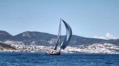 Bodrum, Hindi. 23 Şubat 2024: Yelkenliler Ege Denizi 'nin mavi sularında, ünlü tatil beldesi Bodrum' un kıyılarında rüzgarlı havada yelken açtılar..