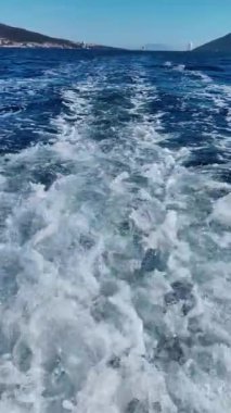 Sürat teknesinin motorundan çıkan dalgaların yakın çekimi. Sosyal medya için dikey video. Yavaş çekim