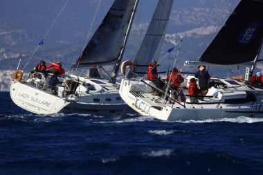 Bodrum, Hindi. 03 Şubat 2024: Ege Denizi 'nin mavi sularında, ünlü tatil beldesi Bodrum' un kıyılarında yelkenliler rüzgarlı havada yelken açıyor.
