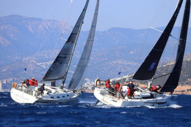 Bodrum, Hindi. 03 Şubat 2024: Ege Denizi 'nin mavi sularında, ünlü tatil beldesi Bodrum' un kıyılarında yelkenliler rüzgarlı havada yelken açıyor.