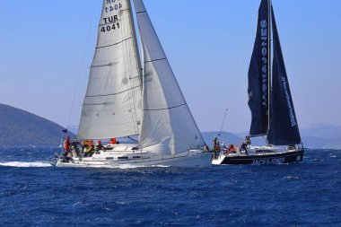 Bodrum, Hindi. 03 Şubat 2024: Ege Denizi 'nin mavi sularında, ünlü tatil beldesi Bodrum' un kıyılarında yelkenliler rüzgarlı havada yelken açıyor.