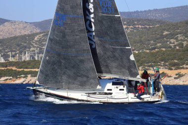 Bodrum, Hindi. 03 Şubat 2024: Ege Denizi 'nin mavi sularında, ünlü tatil beldesi Bodrum' un kıyılarında yelkenliler rüzgarlı havada yelken açıyor.