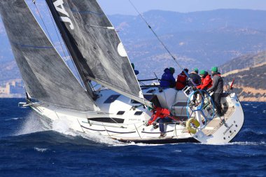 Bodrum, Hindi. 03 Şubat 2024: Ege Denizi 'nin mavi sularında, ünlü tatil beldesi Bodrum' un kıyılarında yelkenliler rüzgarlı havada yelken açıyor.