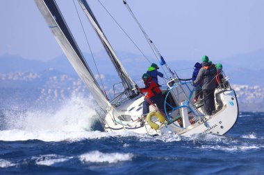Bodrum, Hindi. 03 Şubat 2024: Ege Denizi 'nin mavi sularında, ünlü tatil beldesi Bodrum' un kıyılarında yelkenliler rüzgarlı havada yelken açıyor.