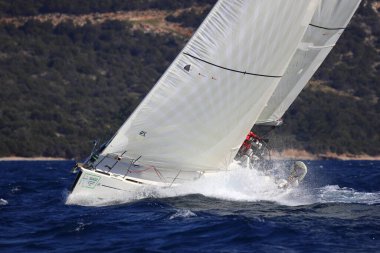 Bodrum, Hindi. 03 Şubat 2024: Ege Denizi 'nin mavi sularında, ünlü tatil beldesi Bodrum' un kıyılarında yelkenliler rüzgarlı havada yelken açıyor.