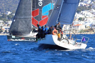 Bodrum, Hindi. 03 Şubat 2024: Ege Denizi 'nin mavi sularında, ünlü tatil beldesi Bodrum' un kıyılarında yelkenliler rüzgarlı havada yelken açıyor.