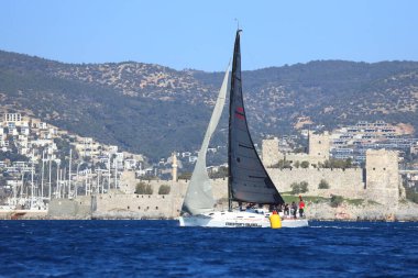 Bodrum, Hindi. 03 Şubat 2024: Ege Denizi 'nin mavi sularında, ünlü tatil beldesi Bodrum' un kıyılarında yelkenliler rüzgarlı havada yelken açıyor.