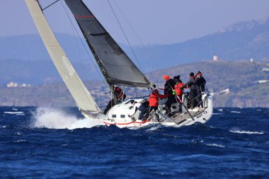 Bodrum, Hindi. 03 Şubat 2024: Ege Denizi 'nin mavi sularında, ünlü tatil beldesi Bodrum' un kıyılarında yelkenliler rüzgarlı havada yelken açıyor.