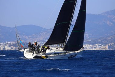 Bodrum, Hindi. 03 Şubat 2024: Ege Denizi 'nin mavi sularında, ünlü tatil beldesi Bodrum' un kıyılarında yelkenliler rüzgarlı havada yelken açıyor.