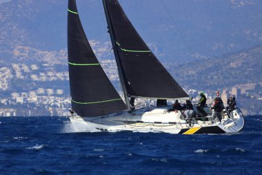 Bodrum, Hindi. 03 Şubat 2024: Ege Denizi 'nin mavi sularında, ünlü tatil beldesi Bodrum' un kıyılarında yelkenliler rüzgarlı havada yelken açıyor.