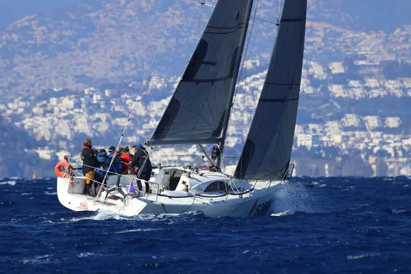 Bodrum, Hindi. 03 Şubat 2024: Ege Denizi 'nin mavi sularında, ünlü tatil beldesi Bodrum' un kıyılarında yelkenliler rüzgarlı havada yelken açıyor.