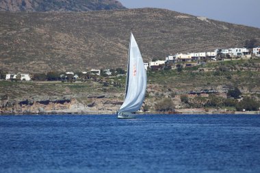 Bodrum, Hindi. 04 Şubat 2024: Ege Denizi 'nin mavi sularında, ünlü tatil beldesi Bodrum' un kıyılarında yelkenliler rüzgarlı havada yelken açıyor.