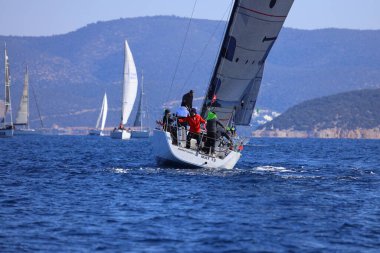 Bodrum, Hindi. 04 Şubat 2024: Ege Denizi 'nin mavi sularında, ünlü tatil beldesi Bodrum' un kıyılarında yelkenliler rüzgarlı havada yelken açıyor.