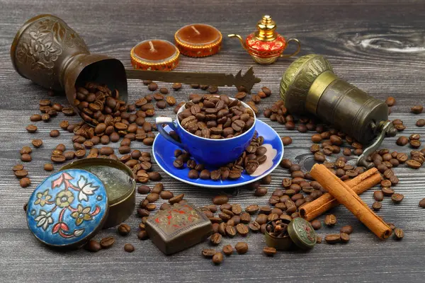Turkish coffee concept. Copper pot (Cezve), vintage coffee grinder, coffee beans on a dark wooden background. Arab Turkish east coffee top view on dark wood background