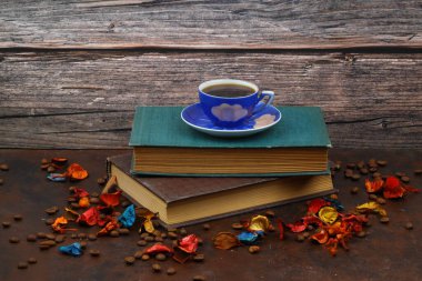 Morning coffee. Cozy composition: a cup of coffee on an open book. Still life concept. Copy space.