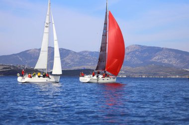 Bodrum, Hindi. 04 Şubat 2024: Ege Denizi 'nin mavi sularında, ünlü tatil beldesi Bodrum' un kıyılarında yelkenliler rüzgarlı havada yelken açıyor.