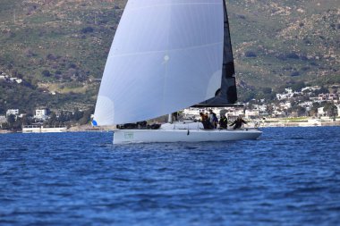 Bodrum, Hindi. 04 Şubat 2024: Ege Denizi 'nin mavi sularında, ünlü tatil beldesi Bodrum' un kıyılarında yelkenliler rüzgarlı havada yelken açıyor.