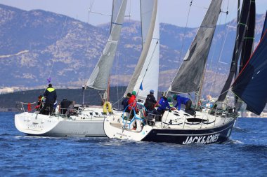 Bodrum, Hindi. 04 Şubat 2024: Ege Denizi 'nin mavi sularında, ünlü tatil beldesi Bodrum' un kıyılarında yelkenliler rüzgarlı havada yelken açıyor.