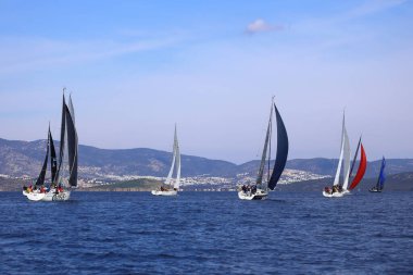 Bodrum, Hindi. 04 Şubat 2024: Ege Denizi 'nin mavi sularında, ünlü tatil beldesi Bodrum' un kıyılarında yelkenliler rüzgarlı havada yelken açıyor.