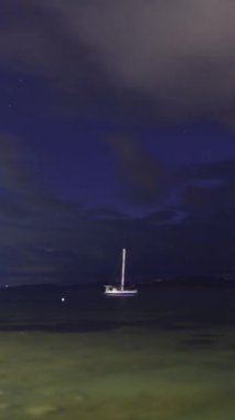 Günbatımında yalnız yelkenli. Atmosferik deniz manzarası. Sosyal medya için dikey video.
