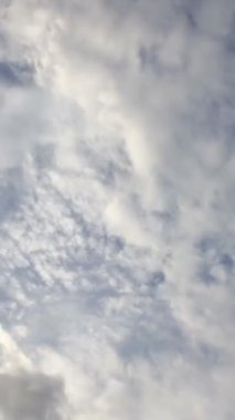 Zaman su gibi akıp geçiyor, bulutlu mavi gökyüzü. Bulutlar. sosyal medya için dikey video.