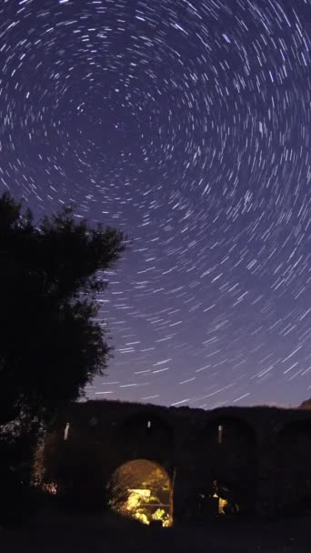 夜の古城に 夜空を移動する星の軌跡のタイムラプス 前景に山頂がある天の川の星の眺め 永遠の気象シャワーの観測 バーティカルビデオ — ストック動画