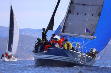 Bodrum, Hindi. 04 Şubat 2024: Ege Denizi 'nin mavi sularında, ünlü tatil beldesi Bodrum' un kıyılarında yelkenliler rüzgarlı havada yelken açıyor.