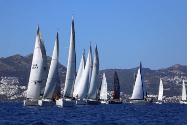 Bodrum, Hindi. 24 Şubat 2024: Ege Denizi 'nin mavi sularında, ünlü tatil beldesi Bodrum' un kıyılarında yelkenliler rüzgarlı havada yelken açıyor.