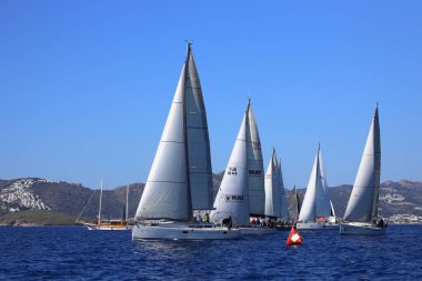 Bodrum, Hindi. 24 Şubat 2024: Ege Denizi 'nin mavi sularında, ünlü tatil beldesi Bodrum' un kıyılarında yelkenliler rüzgarlı havada yelken açıyor.