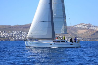 Bodrum, Hindi. 24 Şubat 2024: Ege Denizi 'nin mavi sularında, ünlü tatil beldesi Bodrum' un kıyılarında yelkenliler rüzgarlı havada yelken açıyor.