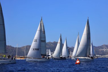 Bodrum, Hindi. 24 Şubat 2024: Ege Denizi 'nin mavi sularında, ünlü tatil beldesi Bodrum' un kıyılarında yelkenliler rüzgarlı havada yelken açıyor.