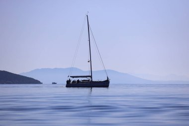 Bodrum, Hindi. 24 Şubat 2024: Ege Denizi 'nin mavi sularında, ünlü tatil beldesi Bodrum' un kıyılarında yelkenliler rüzgarlı havada yelken açıyor.