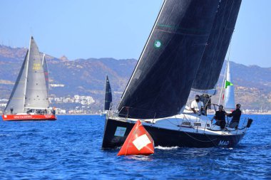 Bodrum, Hindi. 24 Şubat 2024: Ege Denizi 'nin mavi sularında, ünlü tatil beldesi Bodrum' un kıyılarında yelkenliler rüzgarlı havada yelken açıyor.