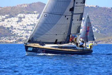 Bodrum, Hindi. 24 Şubat 2024: Ege Denizi 'nin mavi sularında, ünlü tatil beldesi Bodrum' un kıyılarında yelkenliler rüzgarlı havada yelken açıyor.